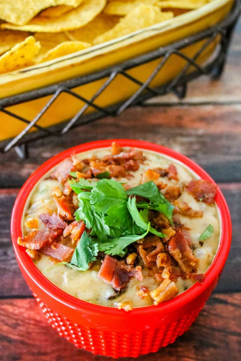 bacon & caramelized onion queso fundido served in a dip bowl with chips