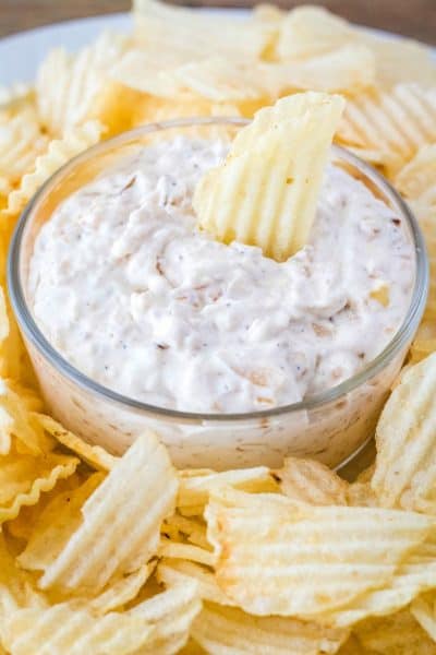 french onio dip in a serving bowl surrounded by potato chips