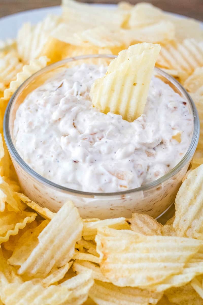 french onio dip in a serving bowl surrounded by potato chips
