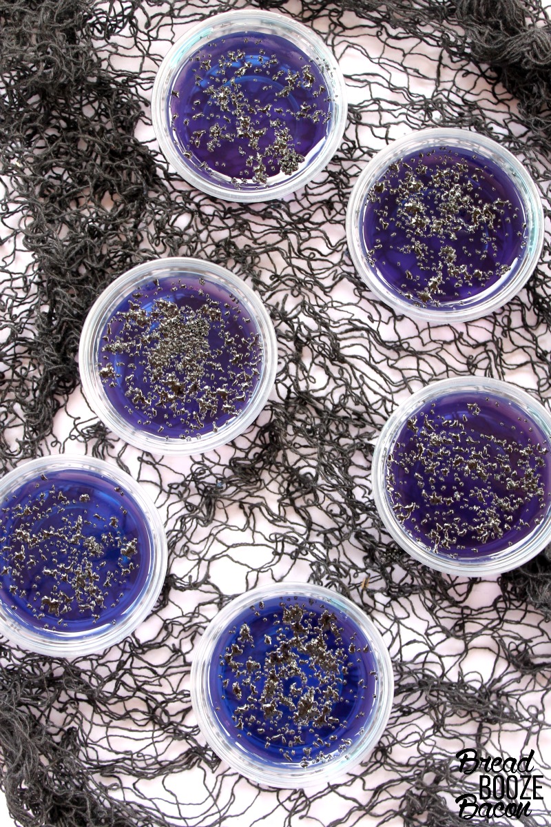 Overhead picture of Black Magic Jello Shots on a black netted Halloween buffet table