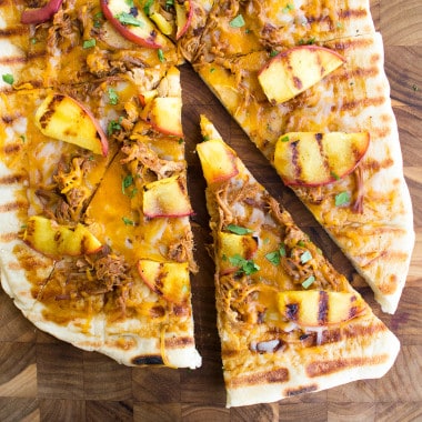 Grilled BBQ Pulled Pork & Peach Gourmet Pizza Recipe is one of those bites of food bliss you just can't stop eating! I love the combination of luscious, fatty pork with fresh peaches and cilantro!