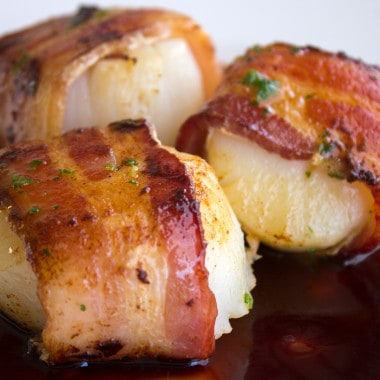 Bacon Wrapped Scallops Recipe with Pomegranate Sauce are a succulent dish that's fancy enough for a dinner party, or serve them family style for your friends!