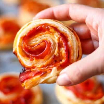 hand holding a Bacon Pinwheel with Cheddar