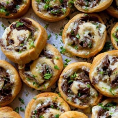 Philly Cheese Steak Pinwheels piled up on a baking sheet