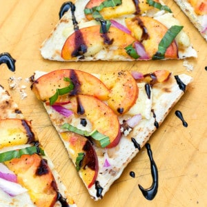 Entertaining doesn't get easier than making this Peach & Brie Flatbread Recipe & opening a bottle of wine! This appetizer is always a hit with our friends!