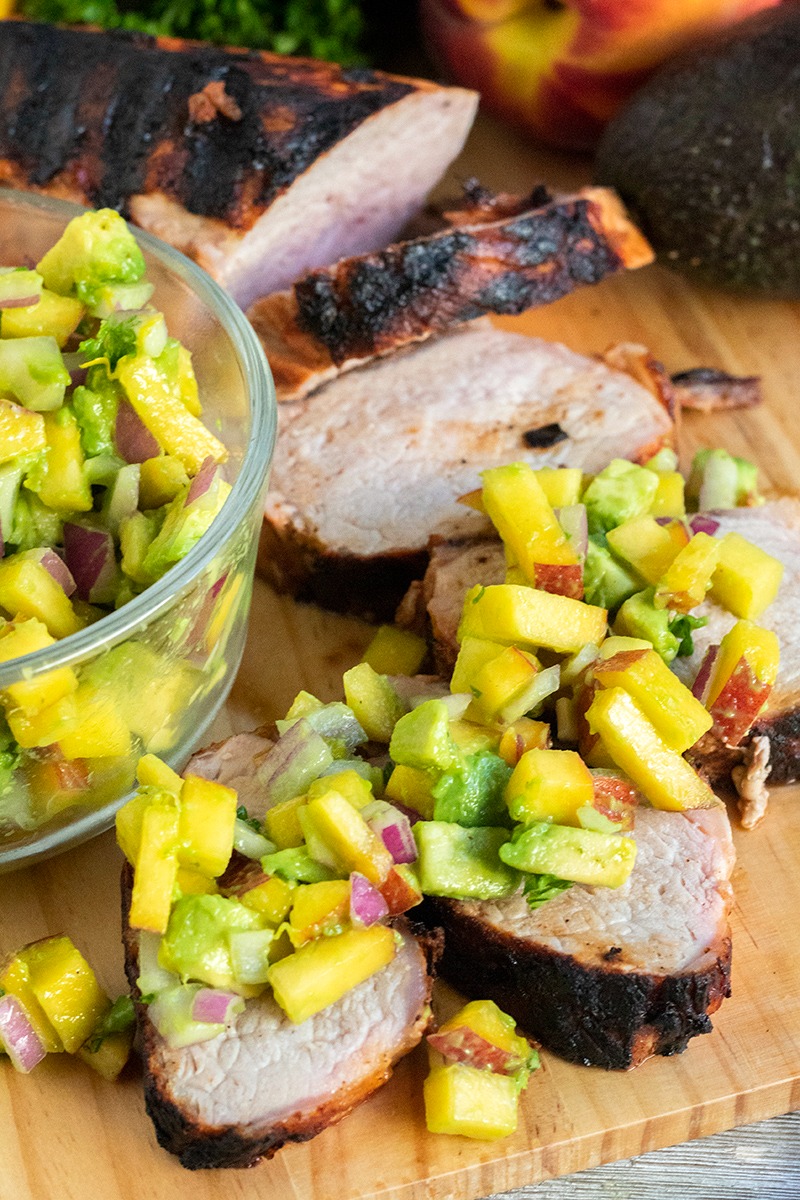 grilled pork tenderloin with avocado peach salsa spooned over the top