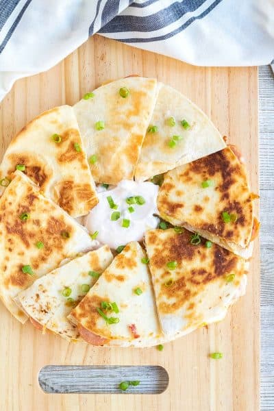 chipotle polish saqusage quesadillas cut into pieces and served with chipotle sour cream