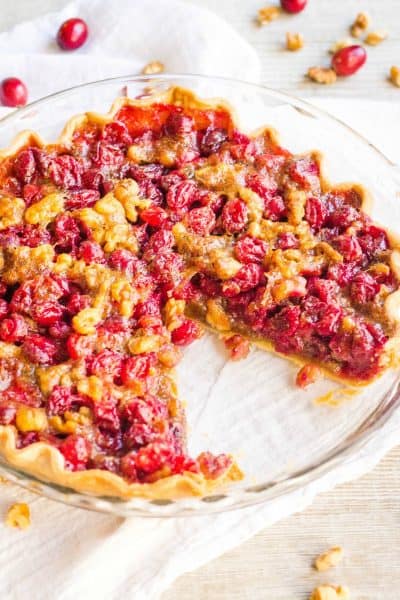 cranberry pie in a pie plate with a slice taken out