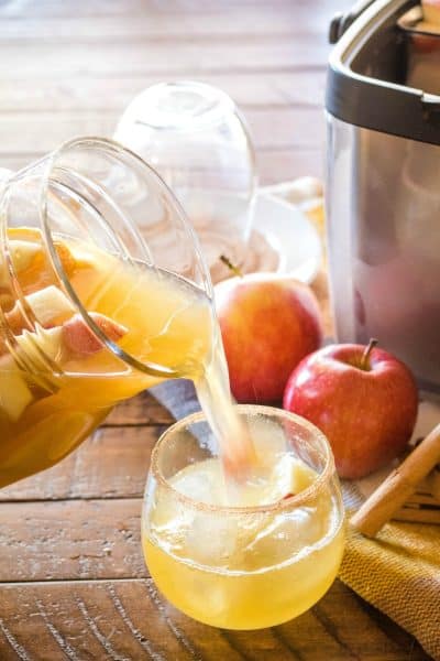 apple cider sangria being poured into wine glasses