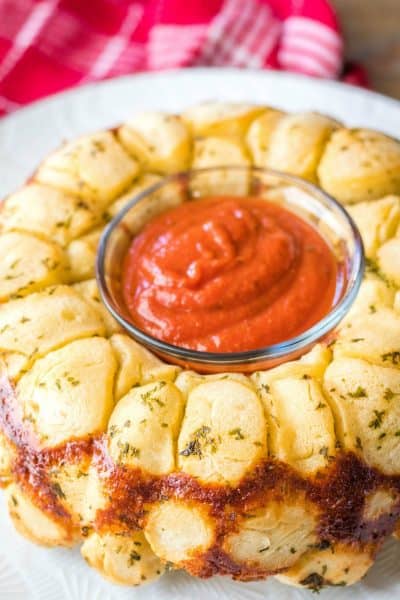 cheesy pull apart gelic bread on a serving plate with pizza sauce for dipping