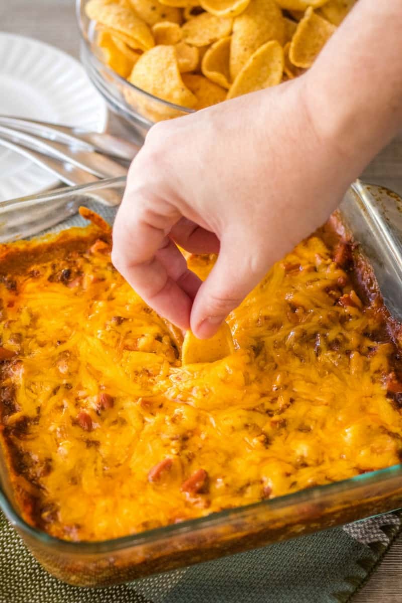 corn chip being dipped into chili cheese dog dip