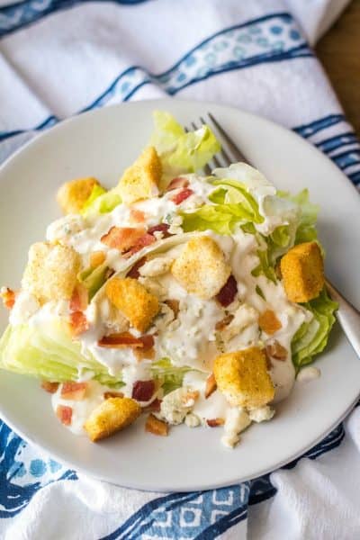 wedge salad topped with blue cheese, bacon, and croutons