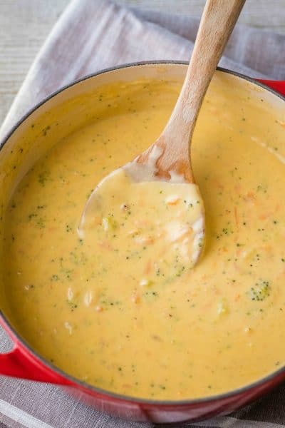 pot of broccoli cheese soup with wooden spoon