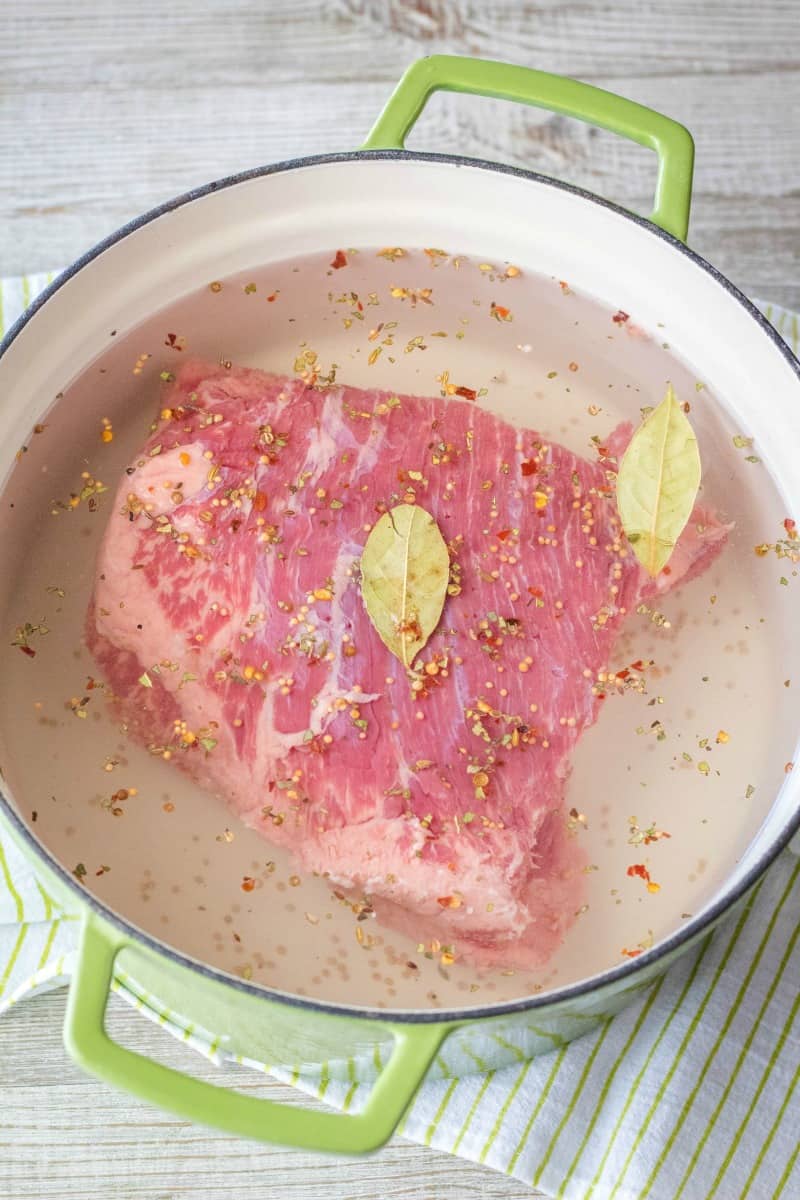 corned beef in a dutche oven with water and spices