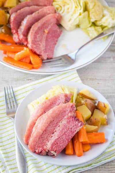 corned beef and cabbage on a dinner plate with a fork and napkin