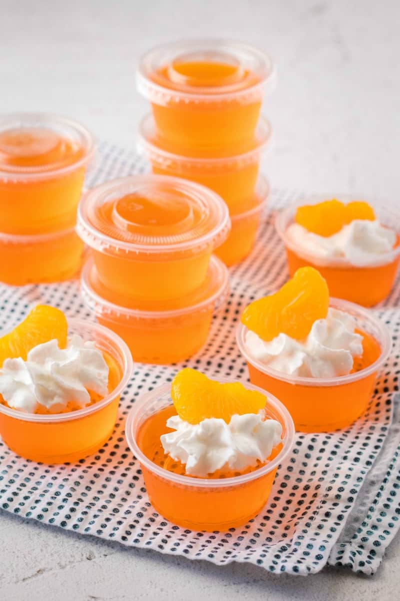 orange creamsicle jello shots tpped with whipped cream & a mandarin orange