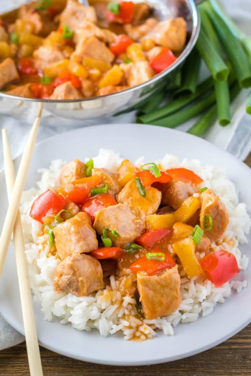 sweet and sour pork served over rice with chopsticks