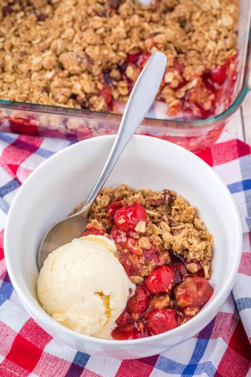 cherry crisp in a bowl with vanilla ice cream