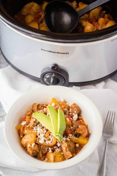 pork tinga in a bowl next to a slow cooker