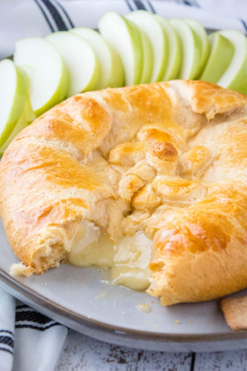 crescent roll baked brie cut open with cheese oozing out