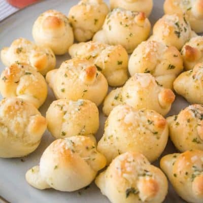 My family can't get enough of these Pizzeria-Style Garlic Knots! Use homemade or store-bought pizza dough, bake until golden, and then dip in marinara!!