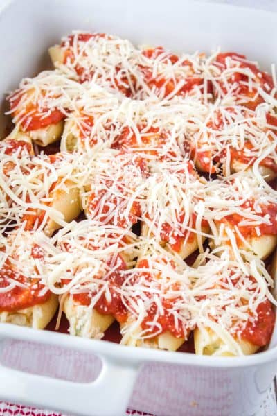 mozzarella cheese sprinkled over stuffed pasta shells and sauce