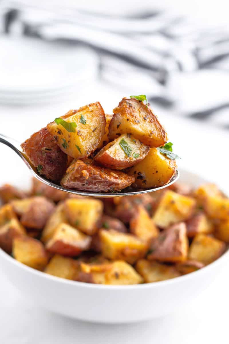 serving spoon with a portion of roasted red potatoes