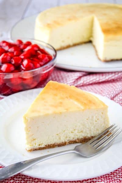 slice of new york cheesecake on a plate with a fork
