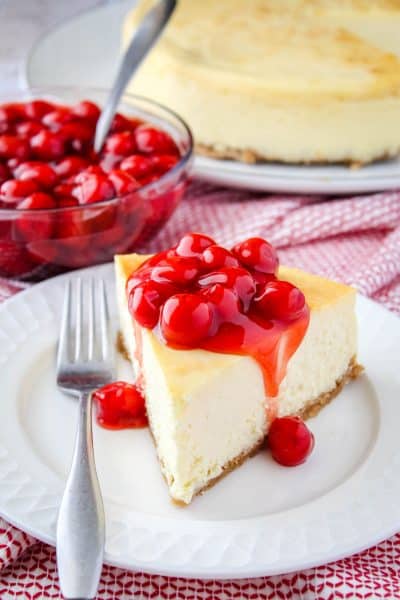 slice of cheesecake with cherries on top