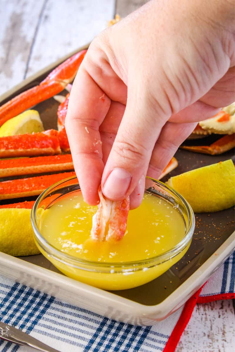 pieces of crab being dipped into clarified butter