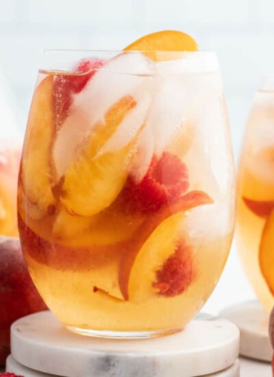 cloe up of a glass of peach moscato punch with raspberries