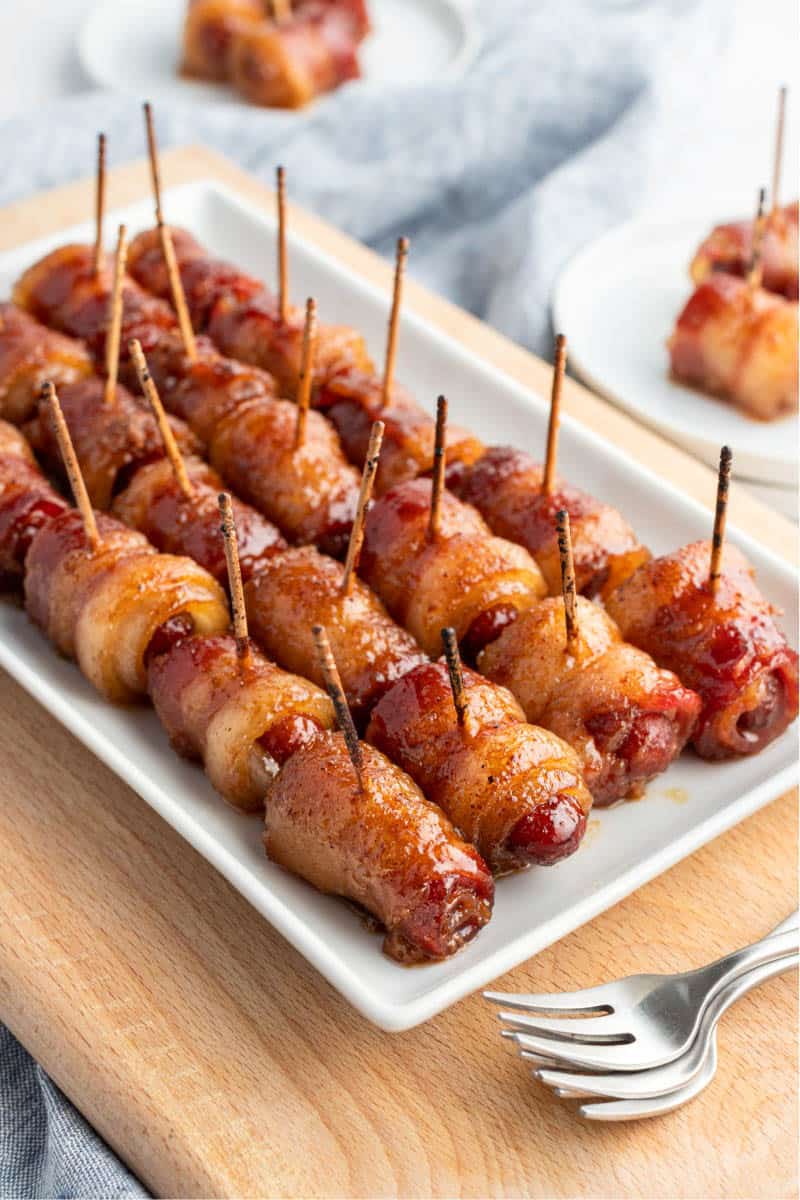 bacon wrapped smokies lined up on a serving platter