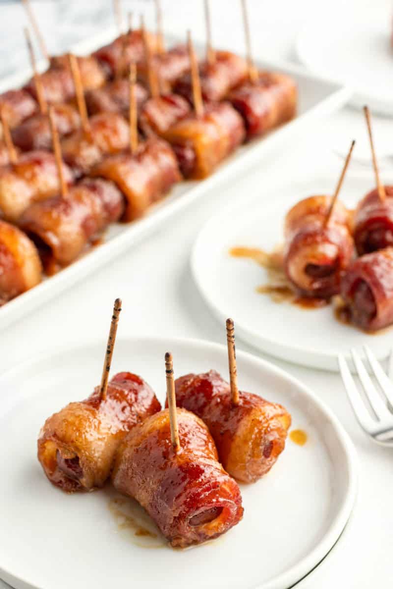 three little smokies wraped in bacon on a small plate