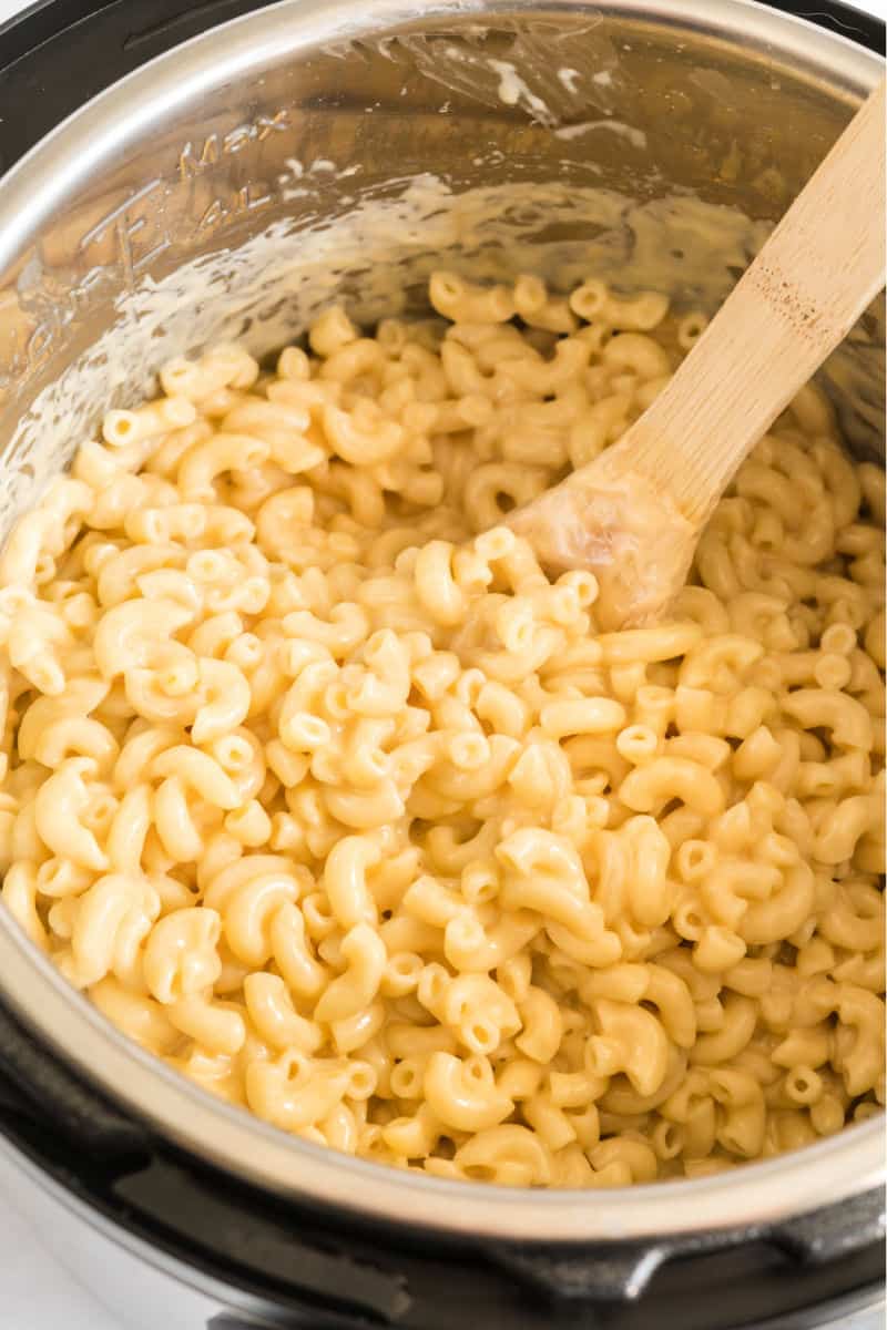 macaroni and cheese in an instant pot with a wooden spoon