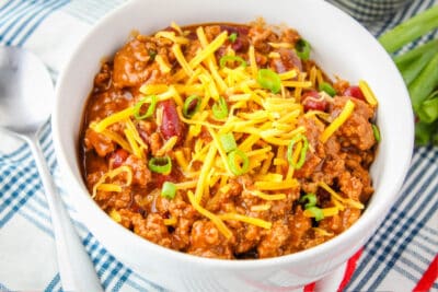 horizontal image of a bowl of chili next to a spoon