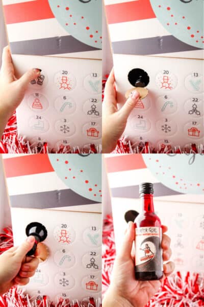 hand opening a wine advent calendar punch out holw and removing wine from the box