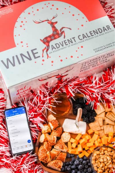 wine advent calendar next to a cheese board and phone with shopping list in Albertsons app