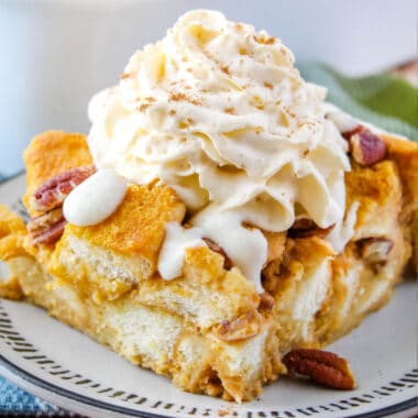 square image of pumpkin bread pudding topped with cream cheese glaze and whipped cream