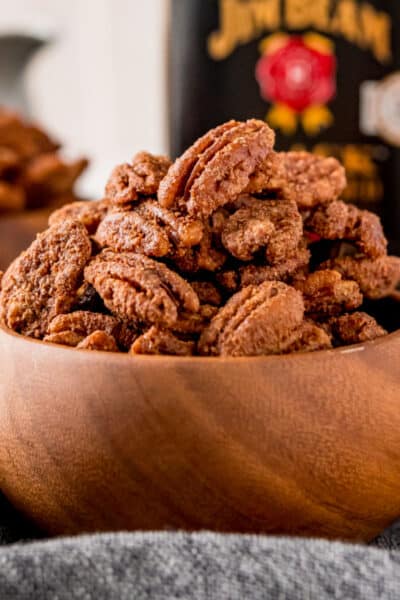 close up of candied pecans in a wooden bowl