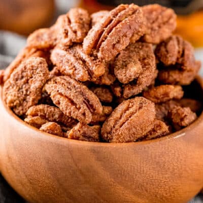 square image of candied pecans in a wooden bowl
