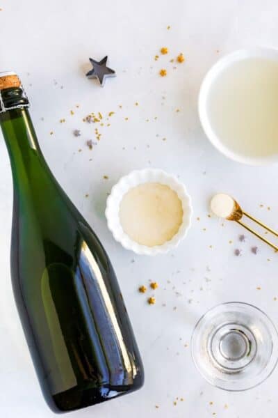 ingredients to make champagne jello shots laid out on a countertop with star sprinkles