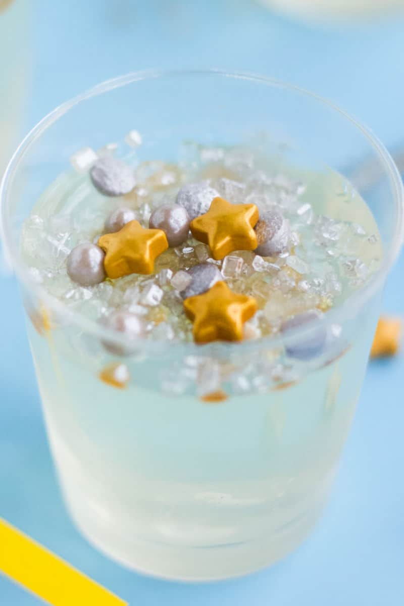 close up of a champagne jello shots topped with gold and silver sprinkles