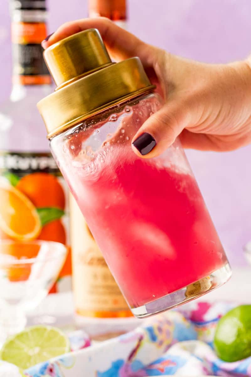 clear cocktail shaker with cosmopolitan ingredients being shaken