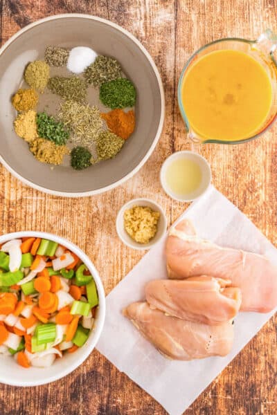 ingredients to make crockpot chicken noodle soup laid on on a tabletop