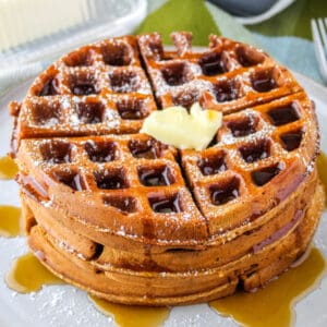 square image of a stack of gingerbread waffles with butter and syrup