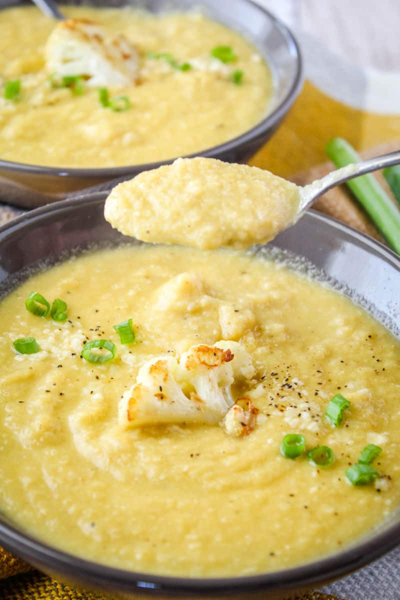 spoonful of roasted garlic & cauliflower soup over a bowl