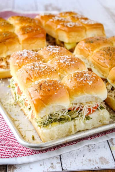 pest chicken sliders on a baking sheet with other types of slider showing toppings on rolls