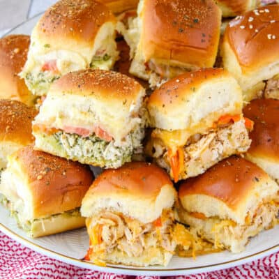 square image of different types of chicken sliders stacked up on a platter