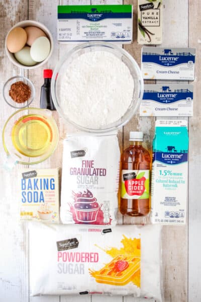 ingredients to make red velvet cake and cream chees frosting laid out on a tabletop