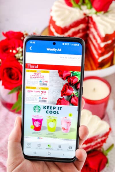 hand holding a smartphone showing floral coupons in Albertsons app